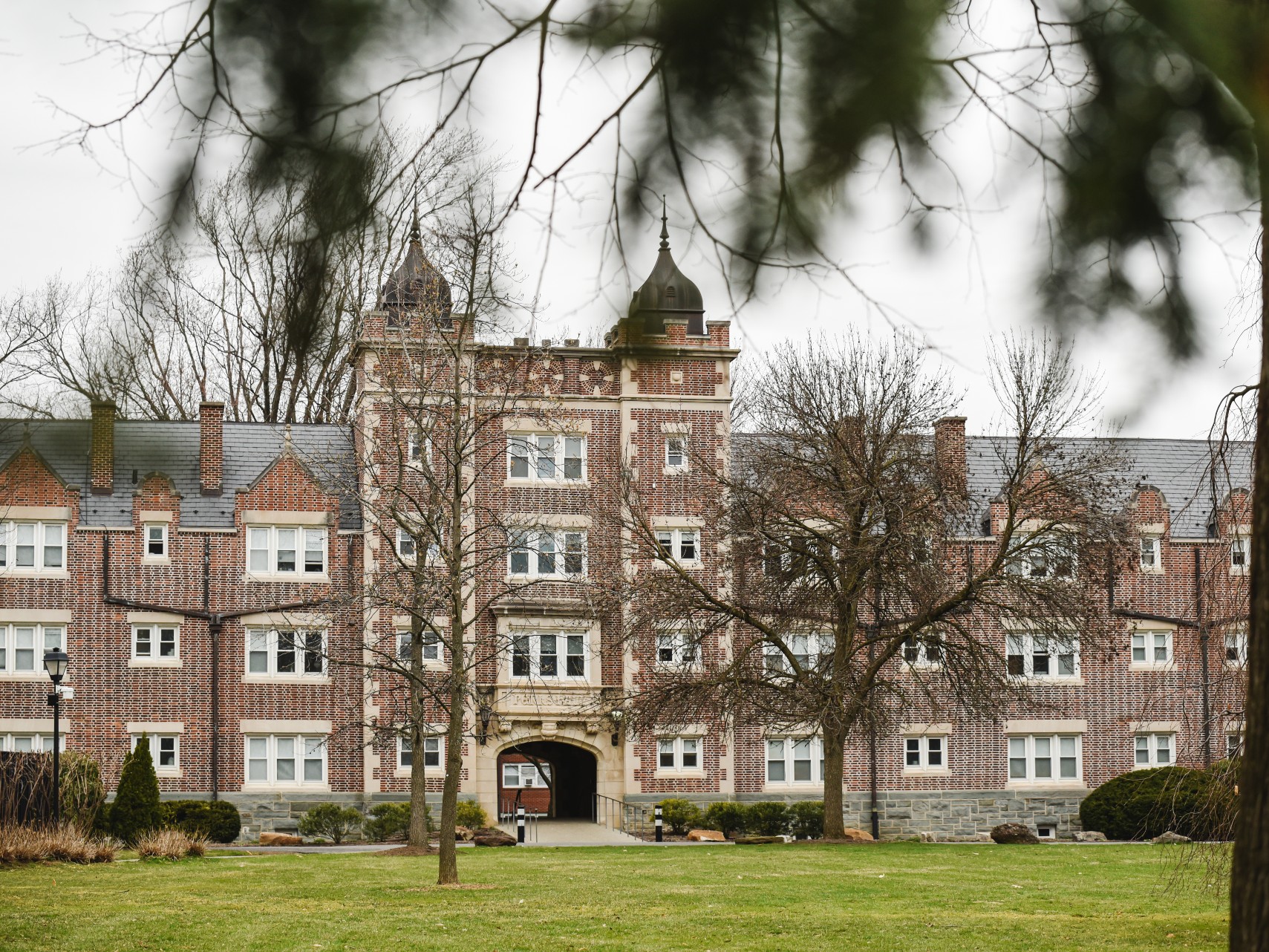 A brown brick college residence hall stands under overcast skies.